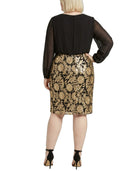 Woman wearing a Calvin Klein black and gold floral dress on a white background