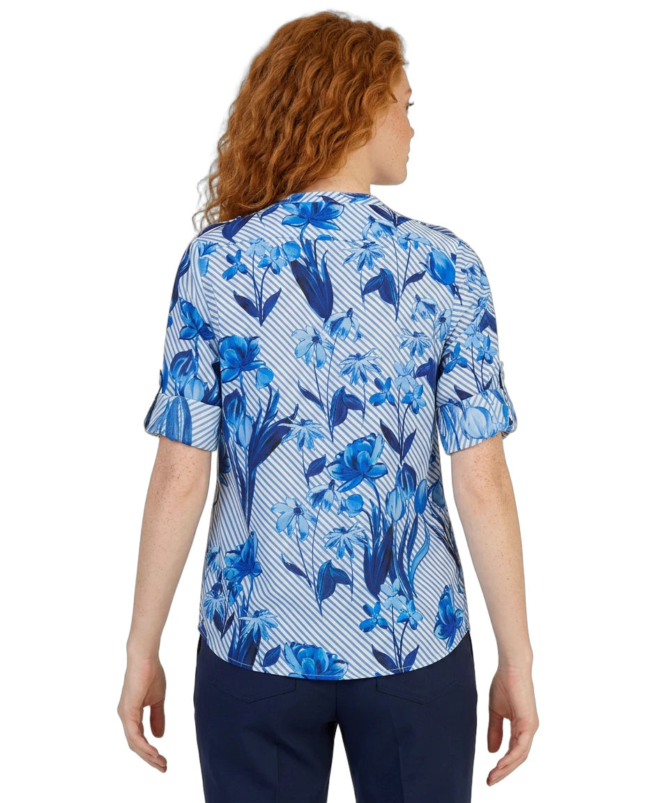 Woman wearing a blue floral Calvin Klein patterned blouse on a white background