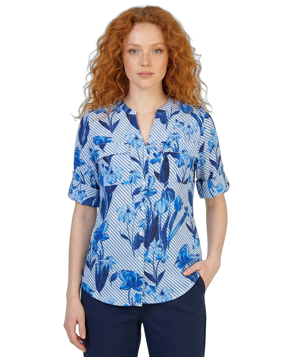 Woman wearing a blue floral patterned Calvin Klein blouse on a white background