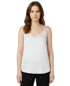 Woman wearing a white Calin Klein sleeveless top on a white background
