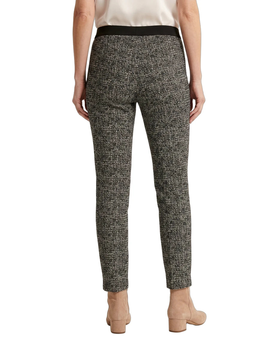 Person wearing black and white patterned Calin Klein pants on a white background