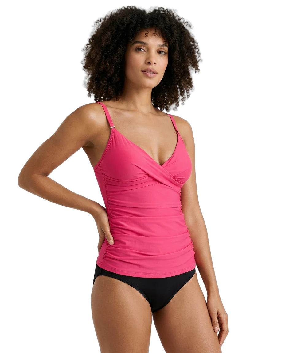 Woman wearing a pink Calvin Klein tankini top and black bottoms on a white background