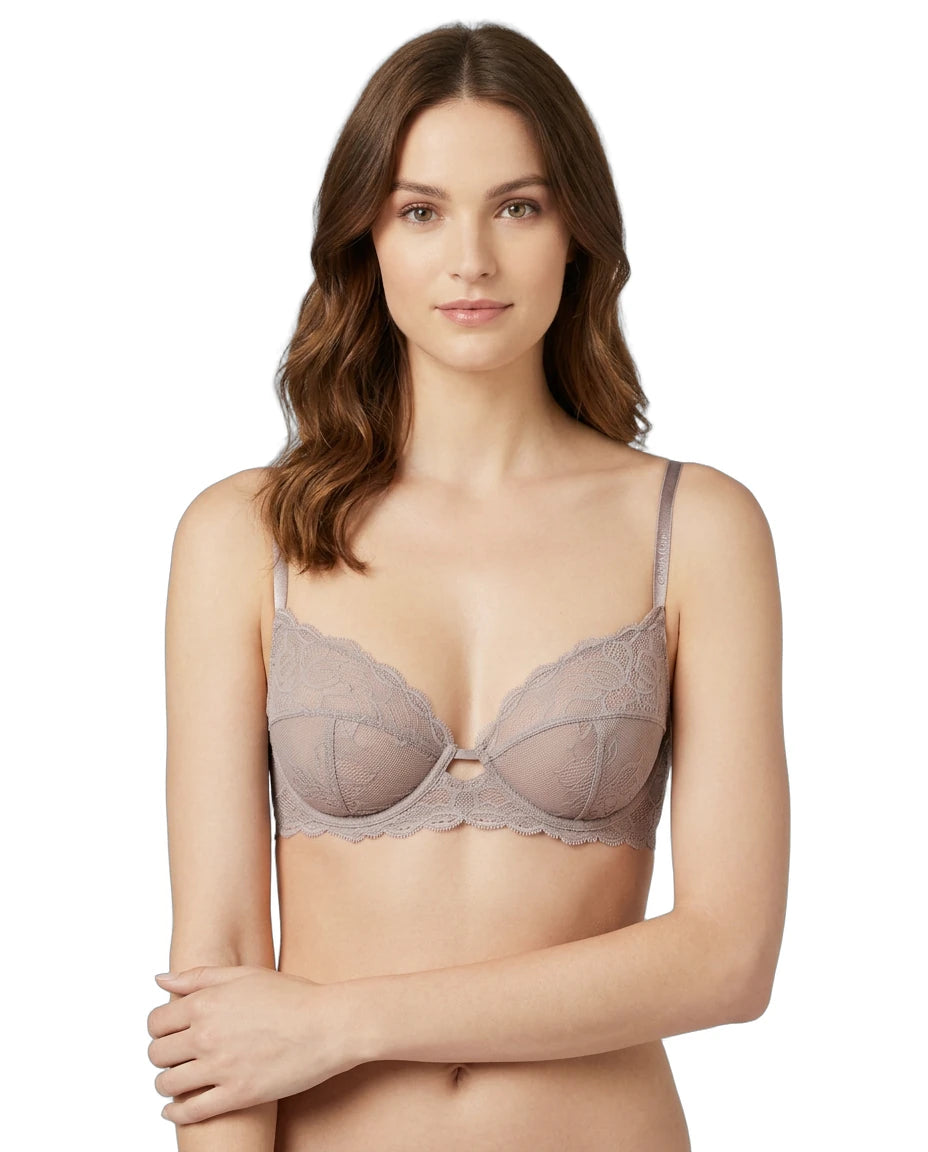 Woman wearing a beige Calvin Klein bra on a white background
