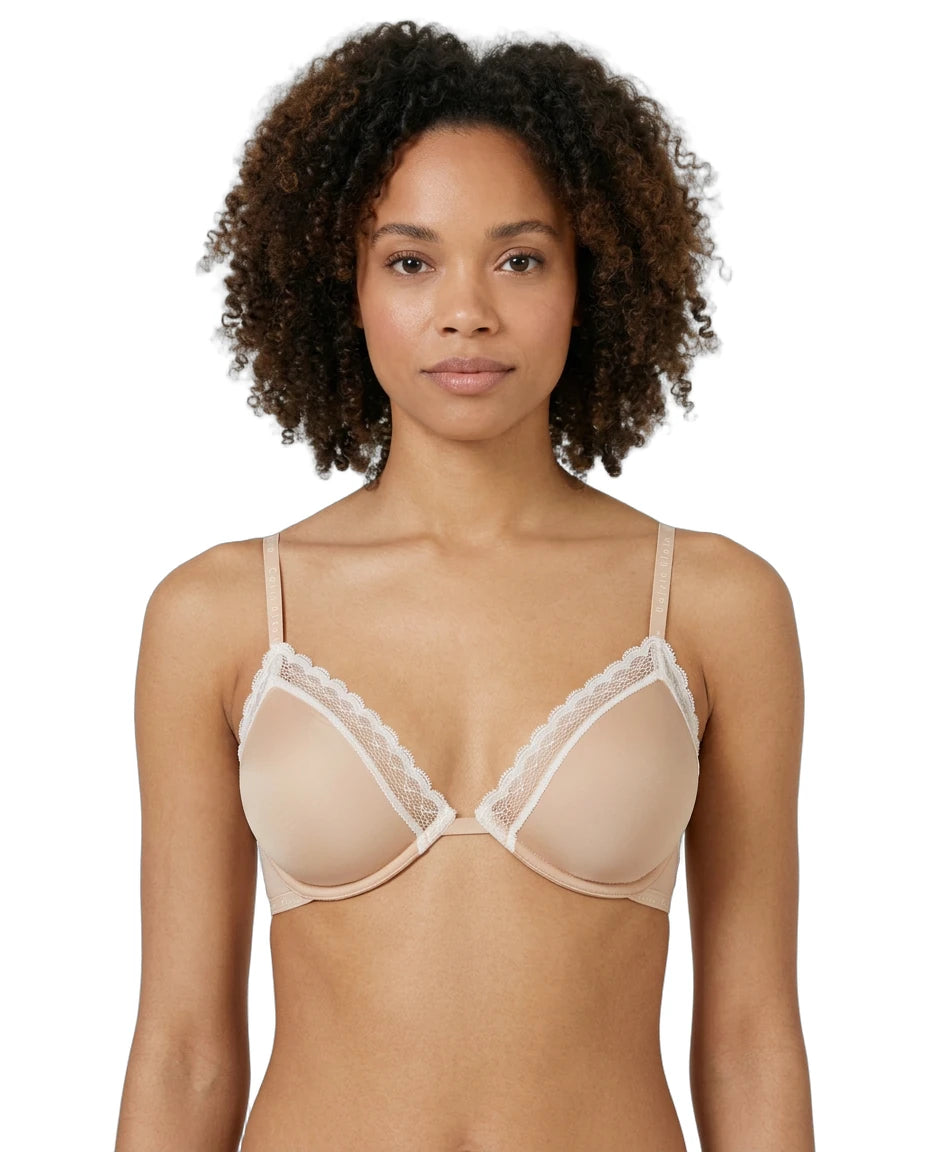 Woman wearing a beige Calvin Klein bra with lace trim on a white background