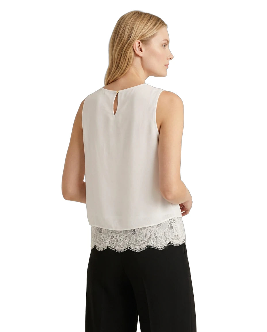 Woman wearing a sleeveless Calvin Klein top with lace trim on a white background