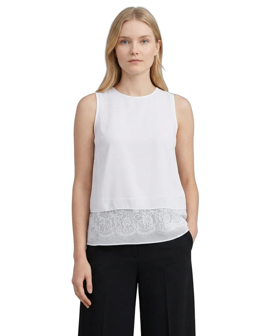 Woman wearing a white sleeveless Calvin Klein top with lace trim on a white background