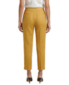 Mustard yellow Calvin Klein pants worn by a person on a white background