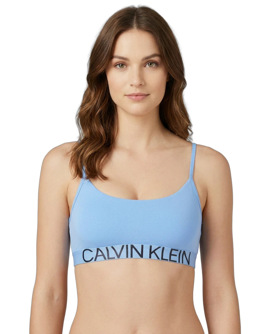 Woman wearing a blue Calvin Klein bralette on a white background