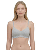 Woman wearing a Calvin Klein bralette on a white background