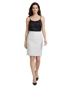 Woman wearing a black top and white skirt on a white background