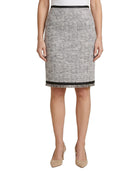 Person wearing a black and white patterned Calvin Klein skirt on a white background