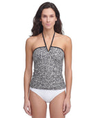 Woman wearing a black and white patterned Calvin Klein tankini with white bottoms on a white background