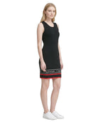 Woman wearing a black Calvin Klein dress with a white background