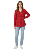 Woman wearing a red plaid Calvin Klein shirt and blue jeans on a white background