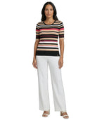 Woman wearing a Calvin Klein striped shirt and white pants on a white background