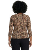 Person wearing a leopard print top with a plain background