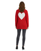 Person wearing a red sweater with a white heart design on the back against a white background