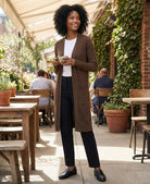 Woman in a brown cardigan standing outdoors at a cafe