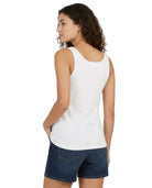 Woman wearing a white tank top and blue shorts on a white background