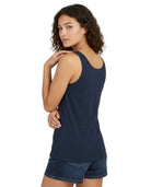 Woman wearing a navy tank top and denim shorts on a white background